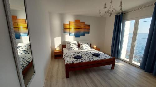 a bedroom with a bed and a large window at Bravarica blue in Potocnica