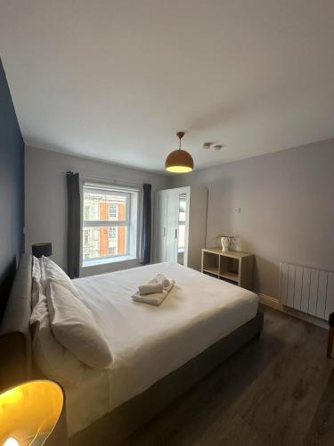 a bedroom with a large white bed and a window at Abbey Apartments in Dublin
