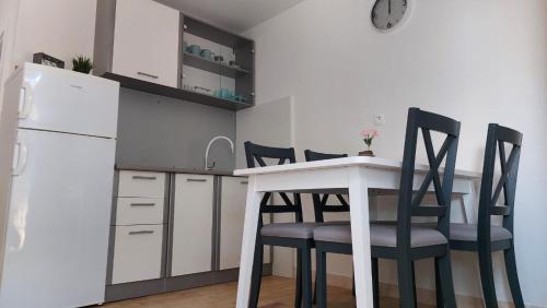 a kitchen with a table and chairs and a refrigerator at Bravarica blue in Potocnica