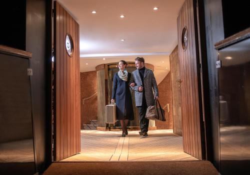 a man and a woman walking through a hallway at Fingal Hotel in Edinburgh