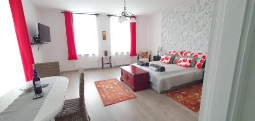a living room with a bed and a table at Virágos Birtok és Vendégház in Villány