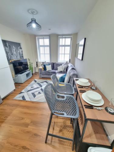 a living room with a couch and a table and chairs at Modern 2BR Flat in Bradford City Centre! in Bradford