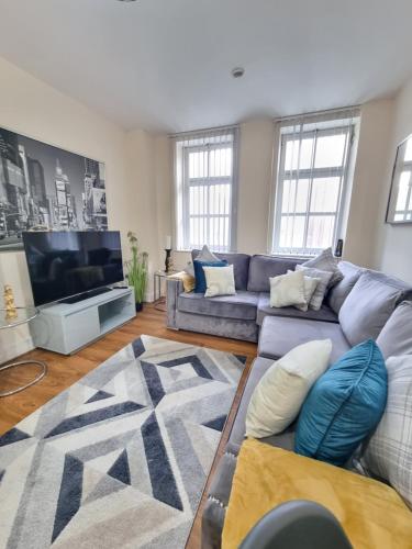 a living room with a couch and a tv at Modern 2BR Flat in Bradford City Centre! in Bradford