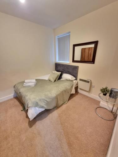 a bedroom with a bed and a mirror on the wall at Modern 2BR Flat in Bradford City Centre! in Bradford