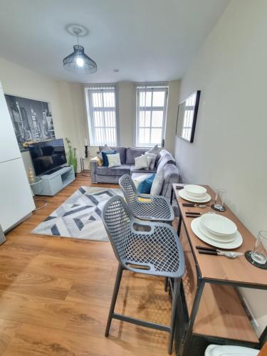 a living room with a table and a couch at Modern 2BR Flat in Bradford City Centre! in Bradford
