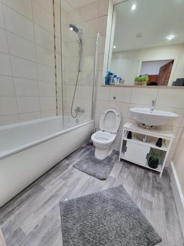 a bathroom with a toilet and a sink and a shower at Modern 2BR Flat in Bradford City Centre! in Bradford