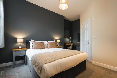 a bedroom with a large bed and two lamps on tables at Rooms at The Dressers Arms in Chorley