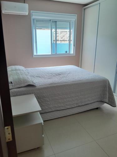 a bedroom with a bed and a window at Morada do Sol in Passo De Torres