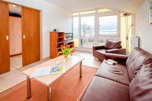 a living room with a couch and a table at Residenz Meeresblick C Fewo 4 in Rerik