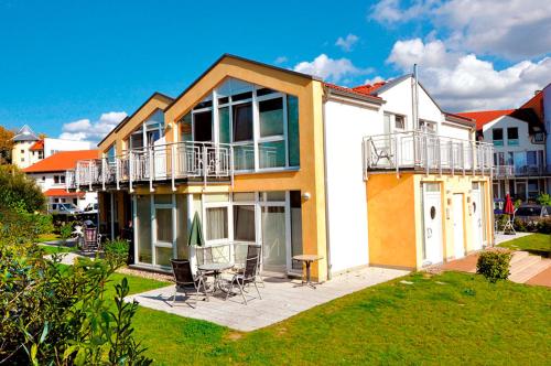 a house with a balcony and a table and chairs at Residenz Meeresblick C Fewo 4 in Rerik
