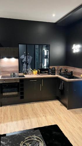 - une cuisine avec des murs noirs et un comptoir dans l'établissement Romantic apartment near Paris, à Maintenon
