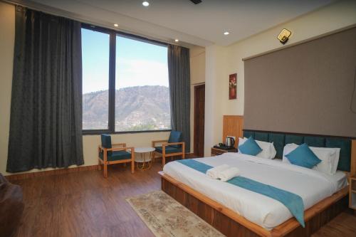 a bedroom with a large bed with a large window at Kasauli Vista in Kasauli