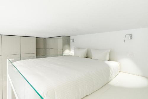 une chambre blanche avec un grand lit blanc dans l'établissement Elegant Luxury Studio Paris 1st, à Paris
