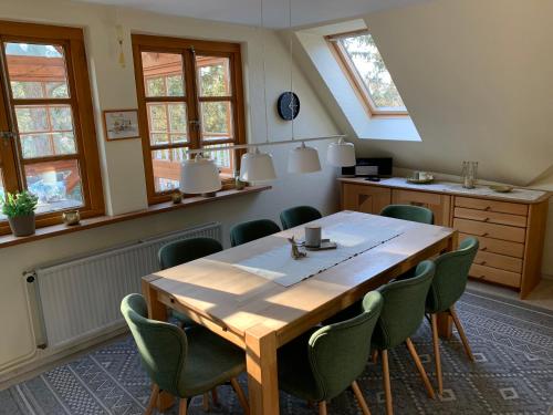 a dining room with a wooden table and green chairs at Sternenhimmel in Bleckede