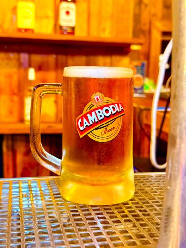 a mug of beer sitting on a metal table at Kohrong Central Beach in Koh Rong Island