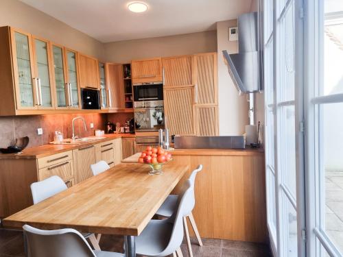 - une cuisine avec une table en bois et des chaises blanches dans l'établissement EXIGEHOME appartement de standing centre ville 3 chambres, au Plessis-Robinson