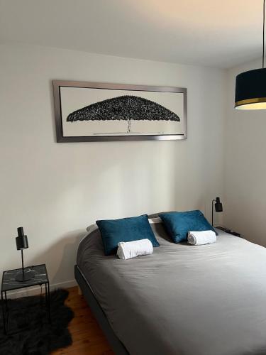 - un lit avec 2 oreillers bleus dans l'établissement Cinema et Billiard, à Charnay-lès-Mâcon