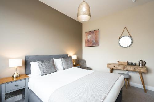 a bedroom with a bed and a table and a mirror at Rooms at The Dressers Arms in Chorley