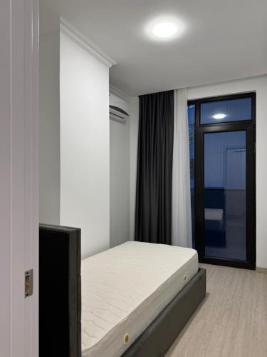 une chambre avec un lit et une grande fenêtre dans l'établissement Almare - by Continental, à Batoumi