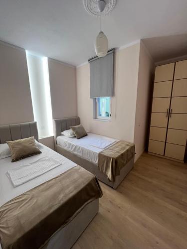 a bedroom with two beds and a window at Bellavista Qerret Apartments in Golem