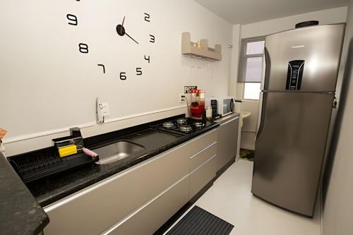 Una cocina con frigorífico de acero inoxidable y fregadero. en Apartamento Confortavel para 5 hospede e Ar, en Foz do Iguaçu