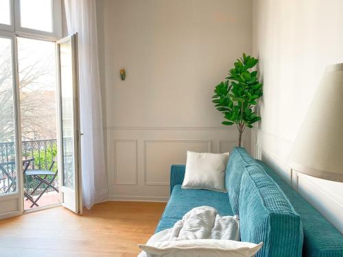 - un canapé bleu dans un salon avec une plante dans l'établissement Charmant 2P avec Balcon, Proche Centre, à Cannes