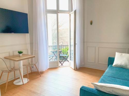 un salon avec un canapé, une table et une fenêtre dans l'établissement Charmant 2P avec Balcon, Proche Centre, à Cannes