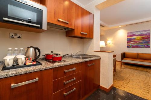 a kitchen with a sink and a microwave at Holiday Inn Kuwait by IHG in Kuwait