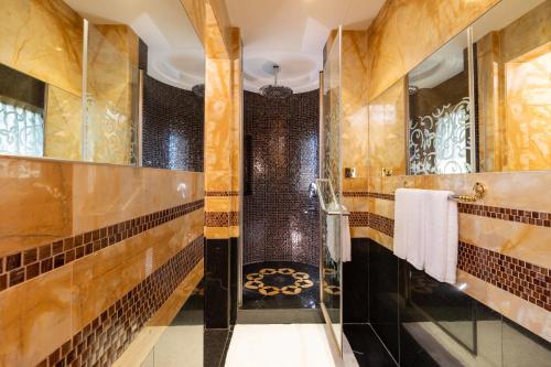 a bathroom with brown tiled walls and a shower at Holiday Inn Kuwait by IHG in Kuwait