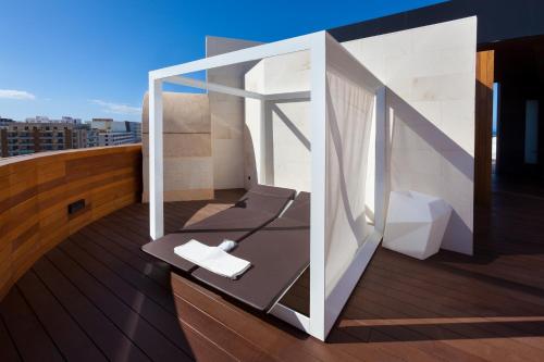 a balcony with a chair on a roof at Tigotan Lovers & Friends Playa de las Americas - Adults Only (+18) in Playa de las Americas