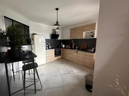 une cuisine avec un réfrigérateur et une table à l'intérieur dans l'établissement Chachou, à Truison