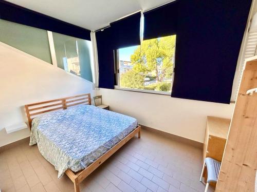 a bedroom with a bed and a large window at MARZIO - appartamenti con terrazzo, posto auto e spiaggia in Marcelli