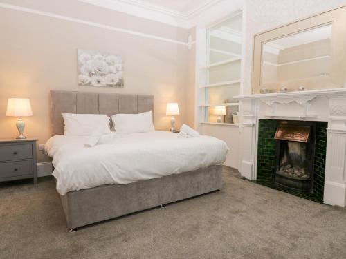 a bedroom with a large bed and a fireplace at Valley View in Dalton in Furness