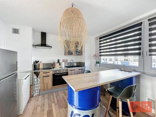 une cuisine avec une grande île dotée d'une poubelle bleue dans l'établissement La détente en amoureux, à Boulogne-sur-Mer