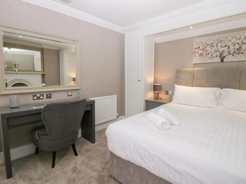 a bedroom with a bed and a desk and a mirror at Valley View in Dalton in Furness