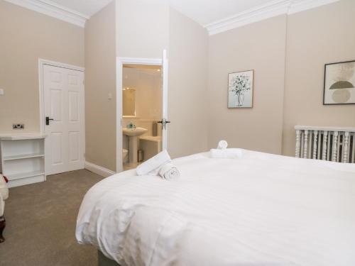 a white bedroom with a white bed and a bathroom at Valley View in Dalton in Furness