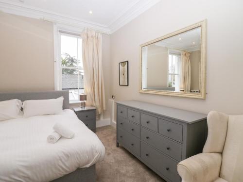 a bedroom with a bed and a mirror and a chair at Valley View in Dalton in Furness