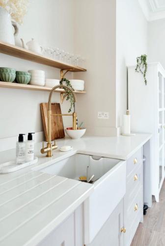 a kitchen with white cabinets and a sink at Driftwood House in Bournemouth