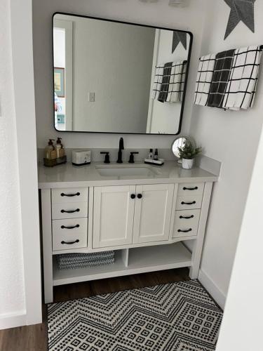 a bathroom with a white sink and a mirror at Cozy Cabin in Brazoria