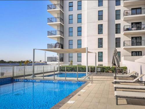 a swimming pool in front of a building at Noor Homes - Luxury Approved by the Department of Culture and Tourism, Abu Dhabi in Yas Island in Abu Dhabi