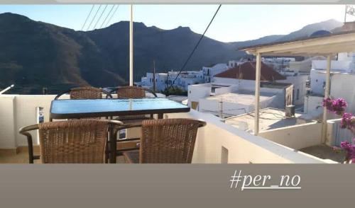 a table and chairs on a balcony with a view at Perno in Serifos Chora