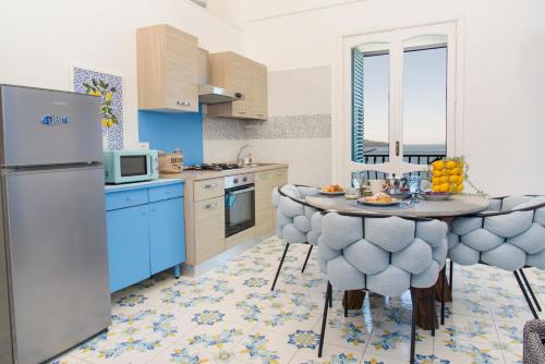 una cucina con tavolo con sedie e frigorifero di Casa Gradoni Anema e Core - De Vivo Realty a Meta