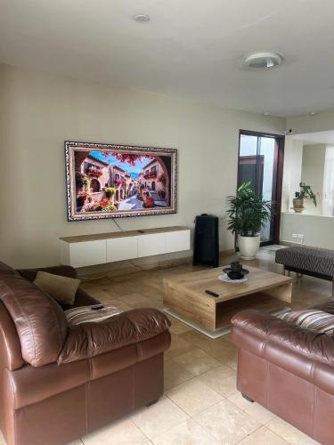 La Molinaにあるcasa Alvaのリビングルーム(茶色の革張りのソファ2台、テーブル付)