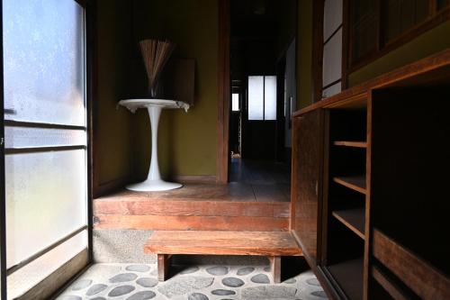 a hallway with a table and a vase in a room at 民泊二七 一棟貸し WiFi完備 袋井駅周辺 敷地内無料駐車場有 in Fukuroi