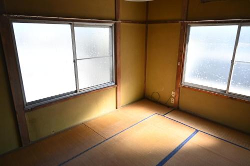an empty room with two windows and a tiled floor at 民泊二七 一棟貸し WiFi完備 袋井駅周辺 敷地内無料駐車場有 in Fukuroi