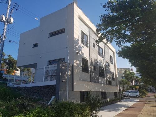 a white building on the side of a street at Yong Stay in Jeju