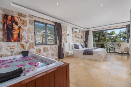 a large bathroom with a tub and a bedroom at Serin Villas in İslâmlar