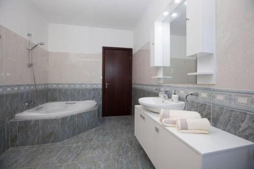 a white bathroom with a sink and a tub and a toilet at Natural Quiet Accommodation 2 - Faliraki in Kalithies