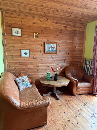 a living room with leather furniture and a table at Gospodarstwo Pytlówka Sokalski Michał in Tarczek