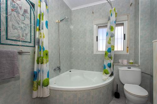 a bathroom with a bath tub and a toilet at CH Limonero Doña Pepa in Rojales
